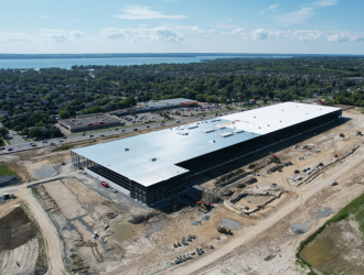 large industrial building development with lake in background